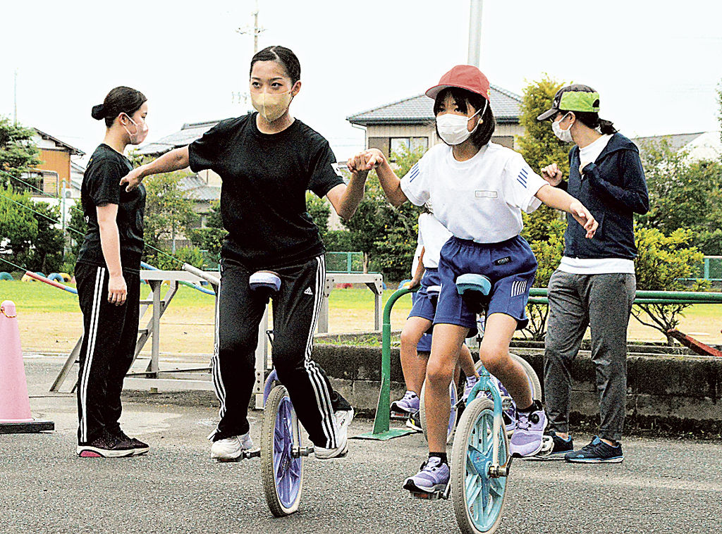 一輪車に挑戦する児童＝磐田市豊浜の豊浜小（写真の一部を加工しています）