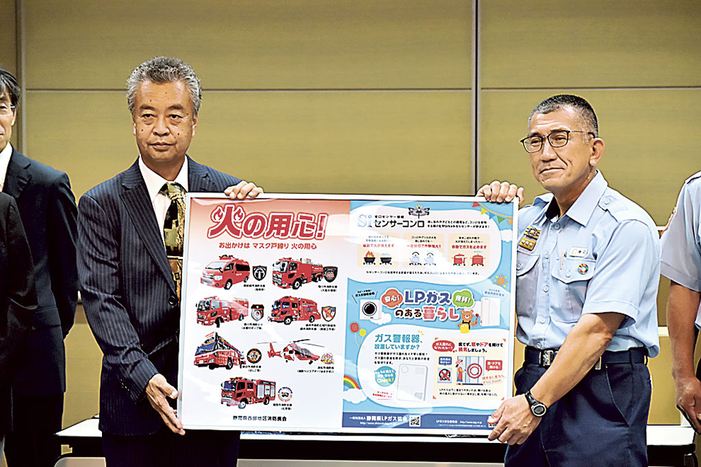 火災予防を啓発するクリアファイルを寄贈した名倉支部長（左）＝浜松市消防局
