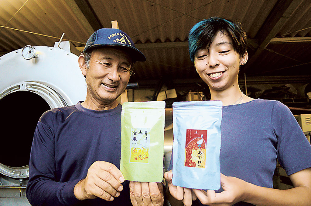 商品を手に笑顔を見せる山本守日瑚代表（左）とフセ・ルナさん＝１４日午後、牧之原市布引原
