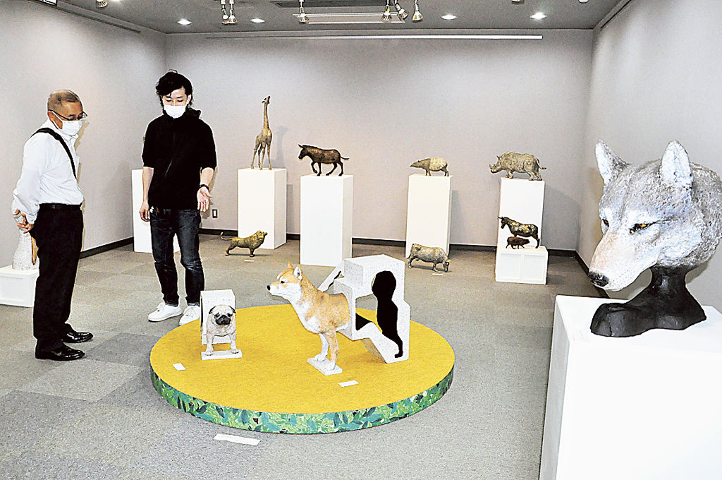 動物をモチーフにした立体作品の説明をする遠藤さん（右）＝小山町総合文化会館