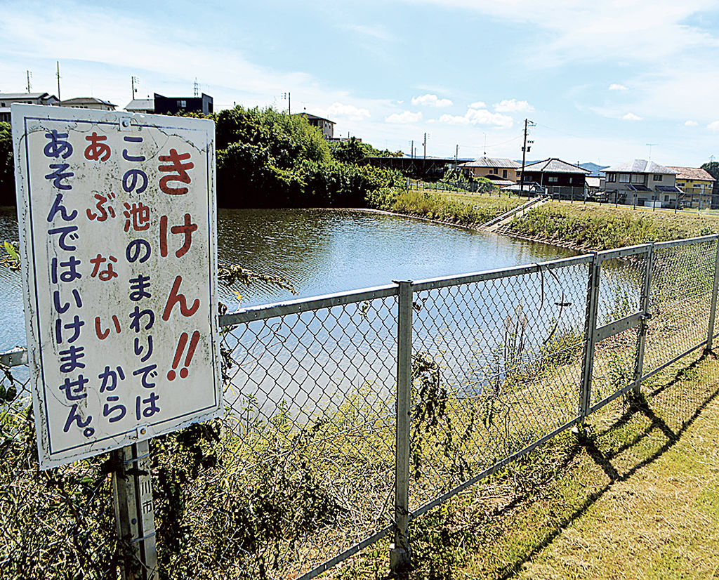 フェンスで覆われたため池。危険性の周知に加え、落下時の救命策を含めた安全対策が求められる＝９月中旬、掛川市内