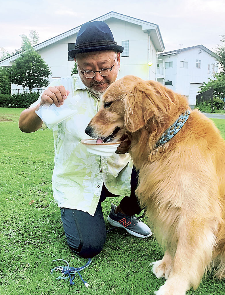 水を入れたパウチ入りのヤギミルクで愛犬に水分補給を促す戸松寛人さん＝８月中旬、清水町内