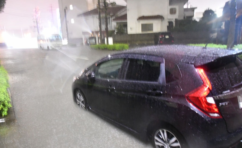 大雨で冠水した道路と立ち往生したとみられる乗用車＝２３日午後８時ごろ、浜松市東区大蒲町