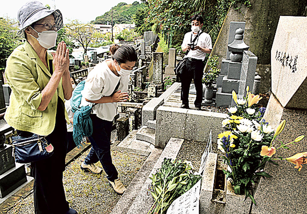 久保山愛吉さんの墓前で手を合わせる参列者＝２３日午前、焼津市浜当目の弘徳院