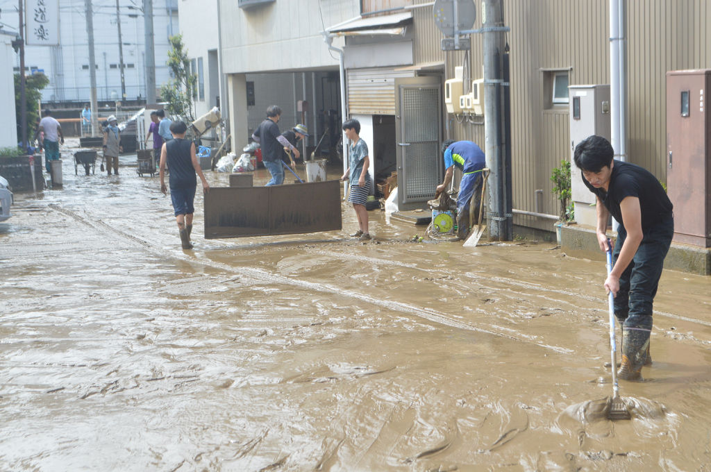 巴川からの浸水被害の後片付けをする住民ら＝２４日午前１０時４５分、静岡市清水区江尻町付近