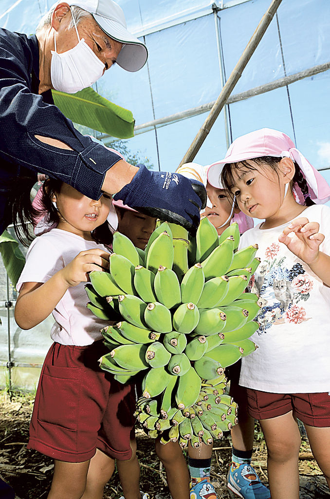 村松さん（左）にバナナを触らせてもらう子どもたち＝浜松市浜北区