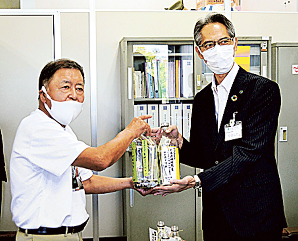 山下健康福祉部長に募金を手渡す森田さん（左）＝浜松市役所