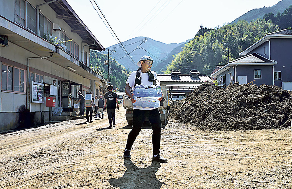 地域住民と救援物資を運ぶ熱海からのボランティア＝３０日午後、静岡市清水区布沢