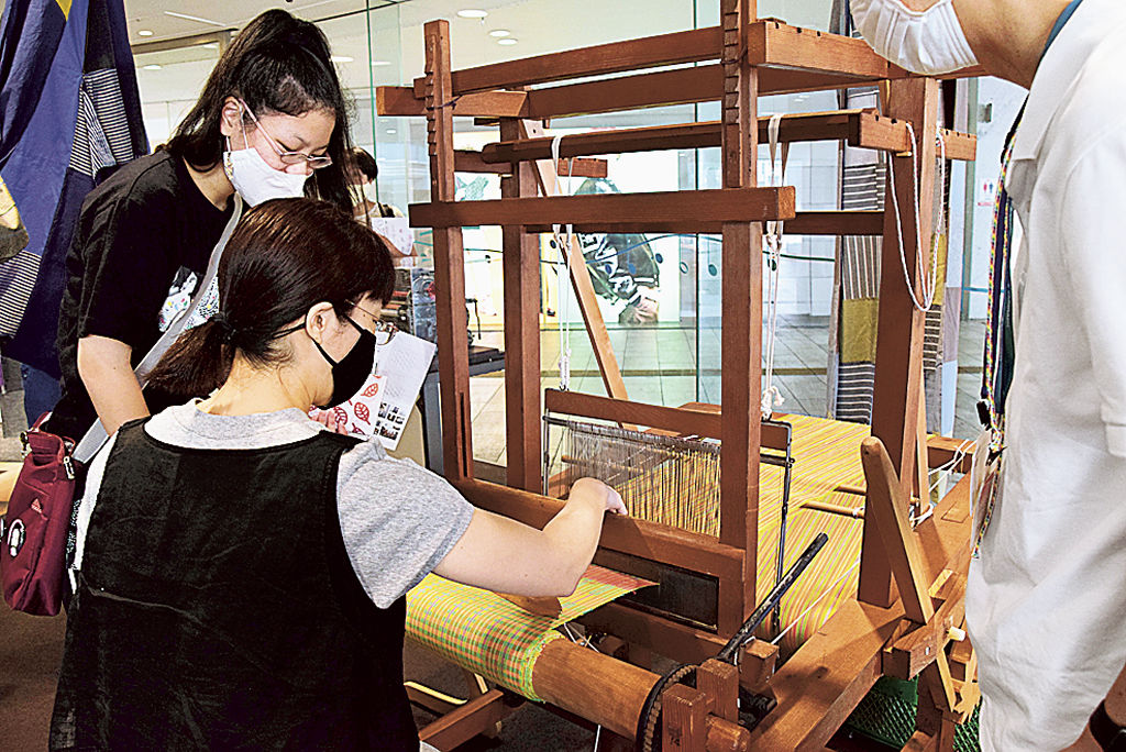 手織り機を体験する親子連れ＝浜松市中区の市ギャラリーモール・ソラモ