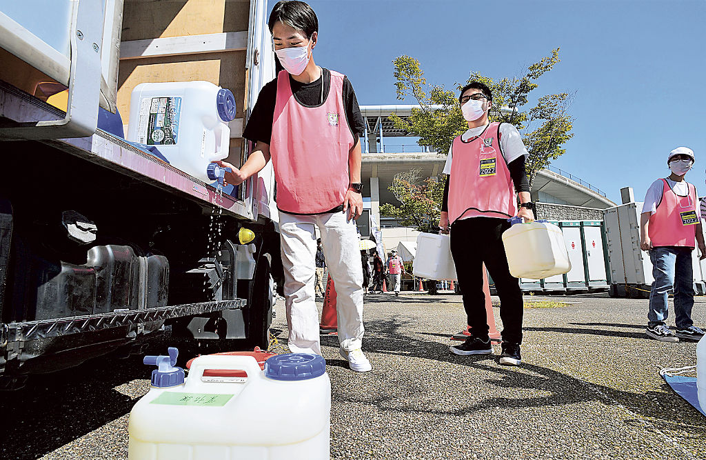 仮設トイレの手洗い用水などを準備するボランティア＝１日午後、藤枝市の藤枝総合運動公園サッカー場