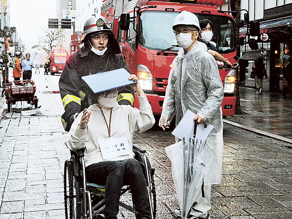 車いす利用者を救護所に搬送する訓練に取り組む参加者＝静岡市葵区