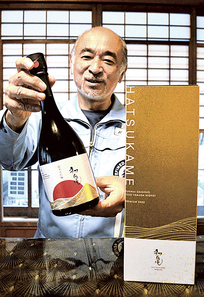 グランプリを受賞した純米大吟醸を手に笑顔を見せる橋本社長＝藤枝市の初亀醸造