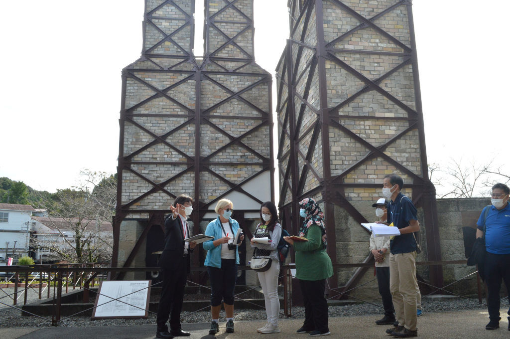 工藤雄一郎課長（左）から説明を受ける審査員ら＝１１日午後、伊豆の国市の世界遺産・韮山反射炉
