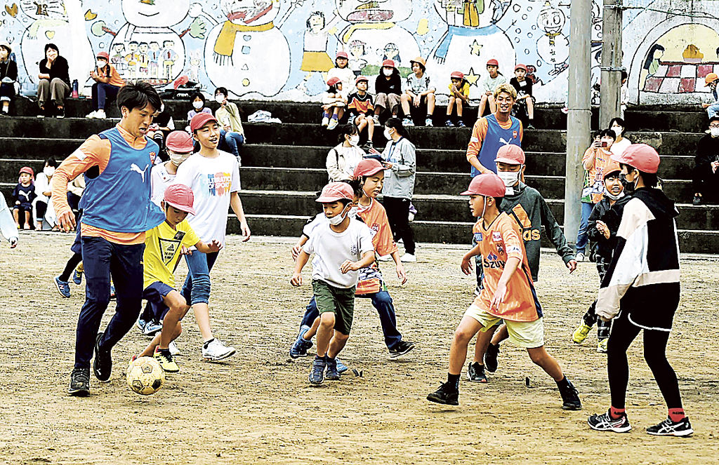 サッカーを通じて触れ合うエスパルスの選手と児童たち＝静岡市清水区の清水小島小