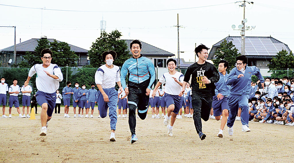 飯塚選手（左から３人目）と競走する生徒ら＝磐田市豊岡の竜洋中