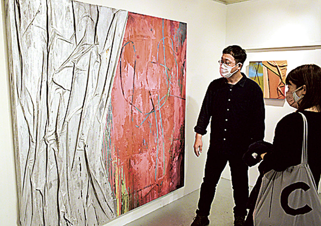 大型作品を説明する鈴木さん（左）＝静岡市葵区のボタニカ・アートスペース