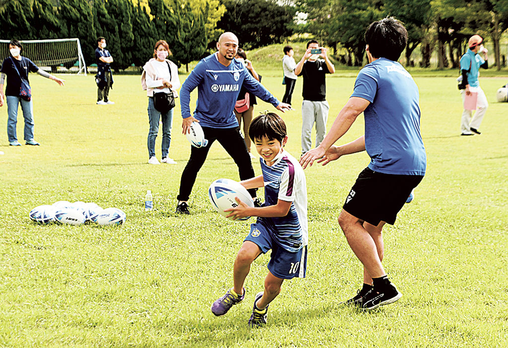 ボールを抱えて懸命に走る子ども＝松崎町の松崎高グラウンド