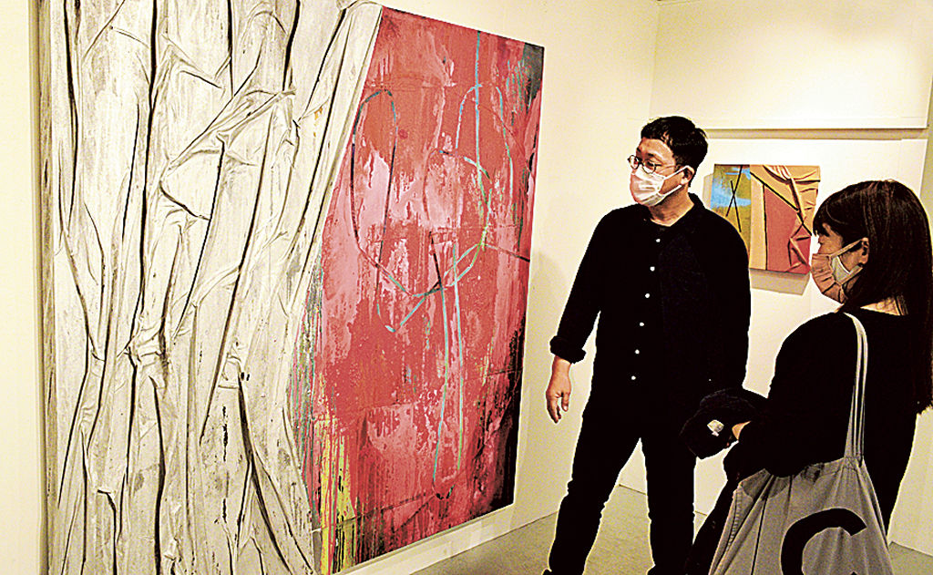 大型作品を説明する鈴木さん（左）＝静岡市葵区のボタニカ・アートスペース