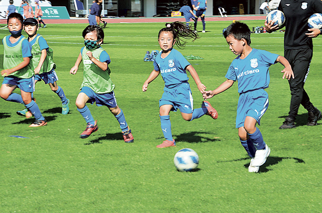 青空の下、ボールを追いかける児童ら＝沼津市の愛鷹広域公園多目的競技場