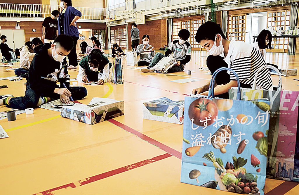 新聞を活用したエコバッグ作りに取り組む児童＝吉田町の中央小