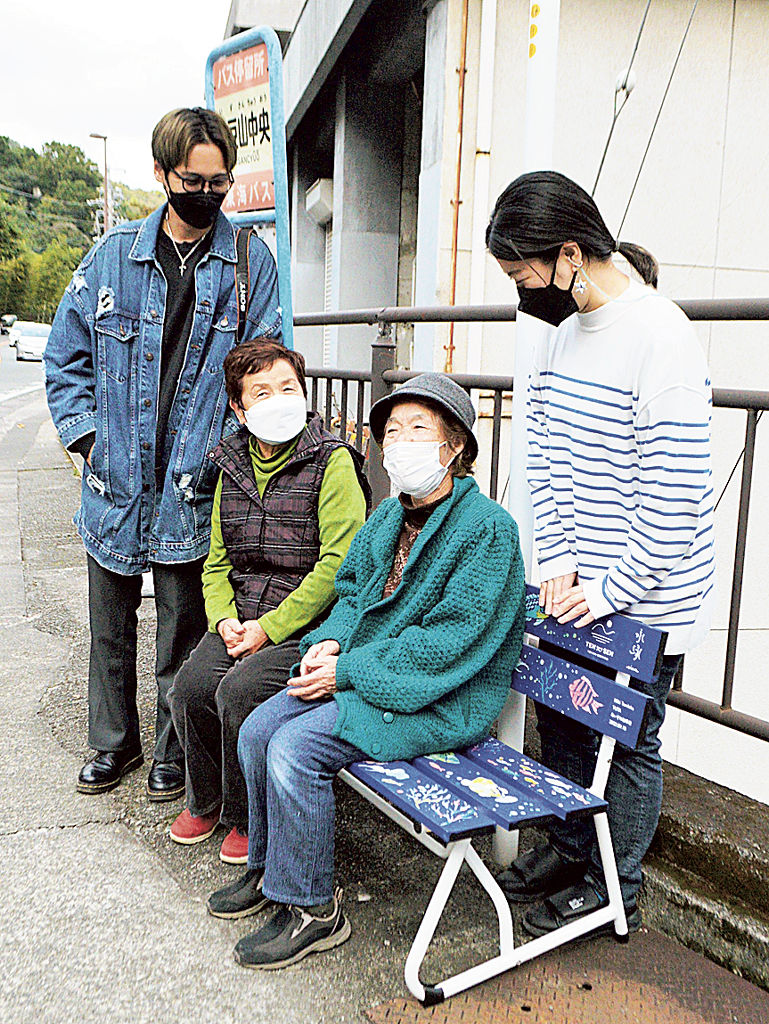 富岡さん（右）とＹＵＴＡさん（左）らが手がけたベンチに腰かける高齢者＝熱海市伊豆山