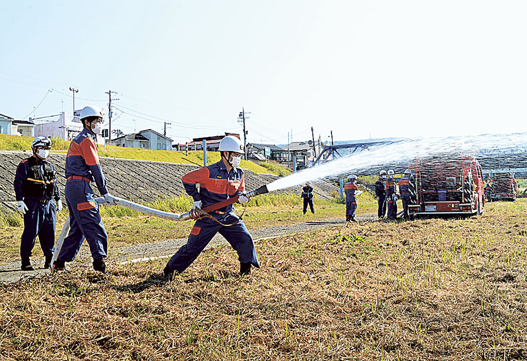 ポンプ車を中継して放水する消防団員ら＝伊豆の国市の狩野川河川敷