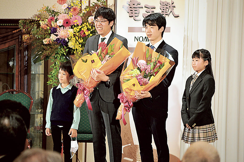 地元小学生から花束を受けた藤井竜王（右から２人目）と広瀬八段（左から２人目）＝富士宮市内