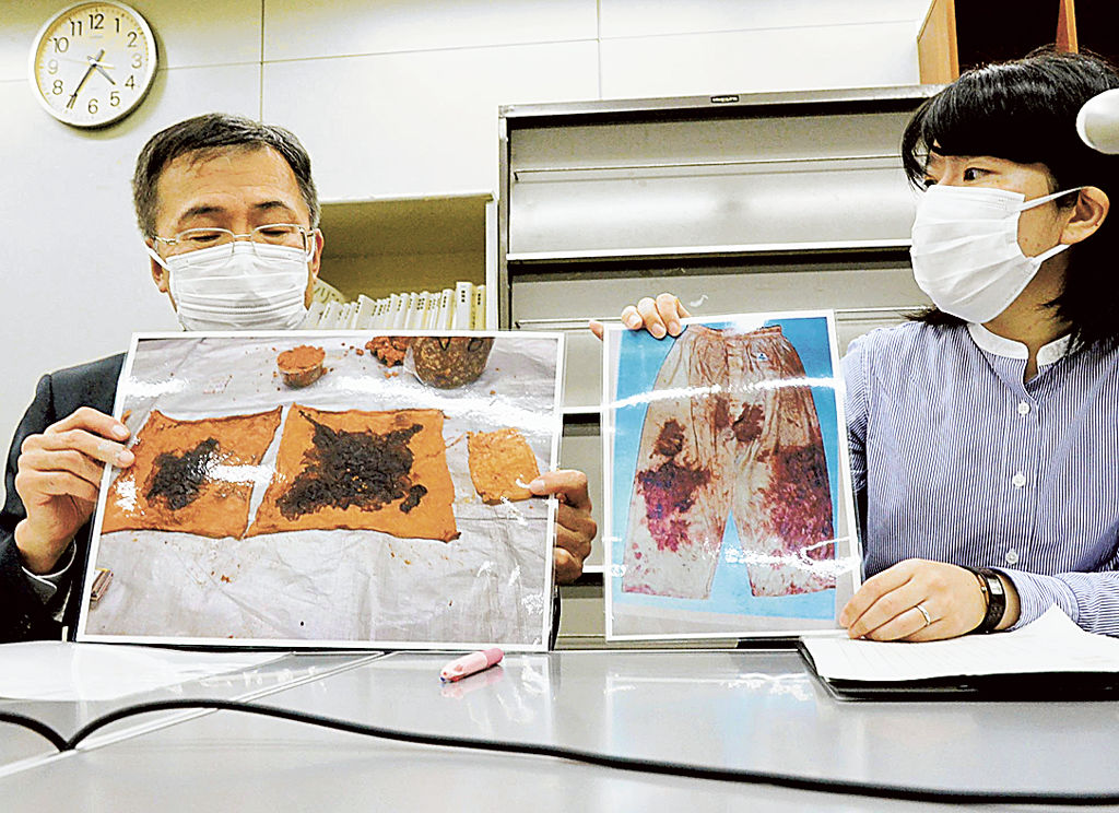検察側「みそ漬け実験」の写真（左）を示しながら血痕の色合いを報告する弁護団。「犯行着衣」の写真（右）は赤みが見て取れるが、検察実験は黒っぽい＝２日午後、県庁