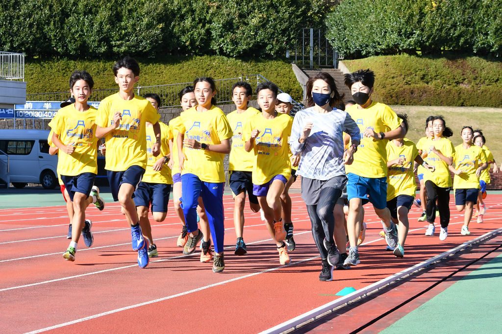 高橋さん（手前右）と走る中学生＝富士市の富士総合運動公園陸上競技場