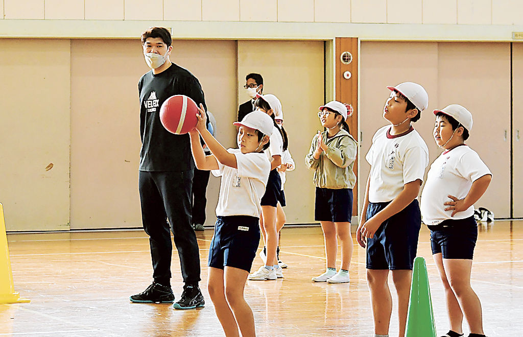 高村コーチ（左）に教わった捕球姿勢を実践する児童＝富士市の神戸小