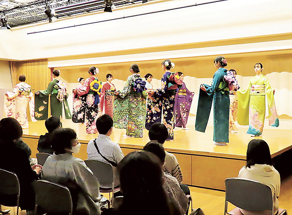 ステージ上を歩き、華やかな振り袖と帯結びを披露する参加者＝浜松市中区のあいホール