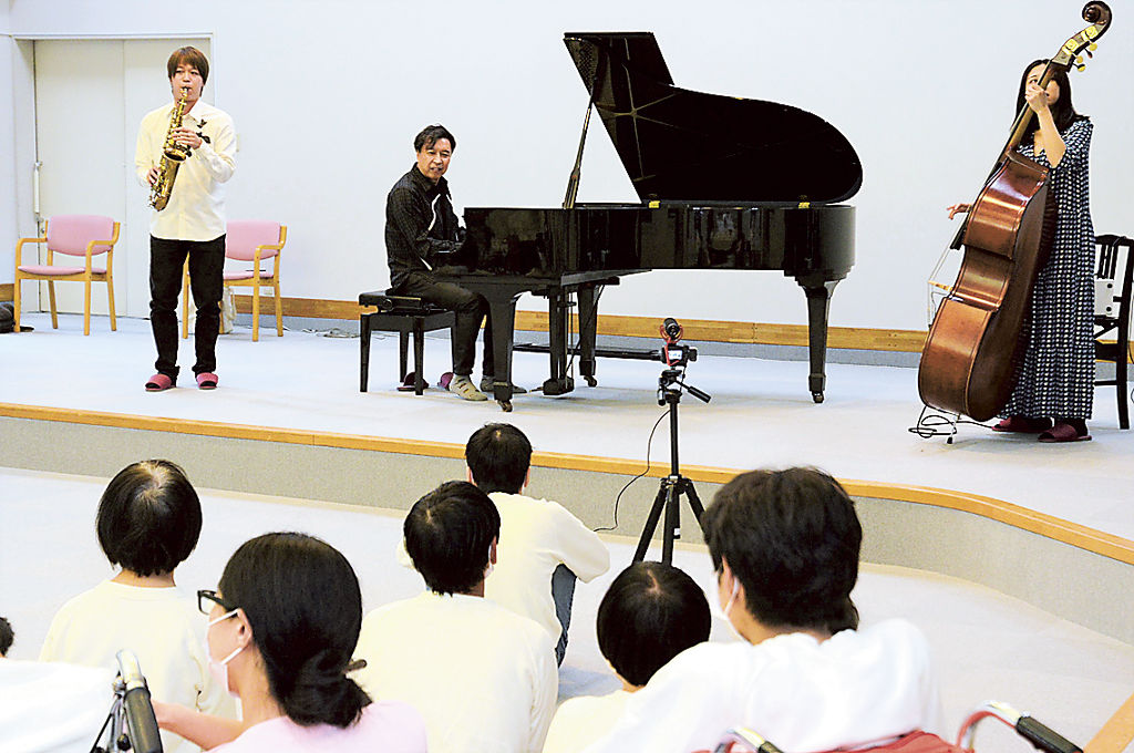 利用者にピアノ演奏を届ける小曽根さん＝掛川市上垂木のねむの木学園