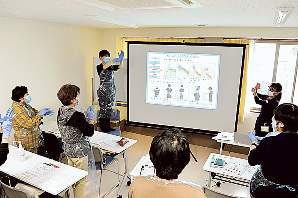 リーダー育成研修で防護具の着脱方法を学ぶ参加者＝９日午前、焼津市の大富陽光園