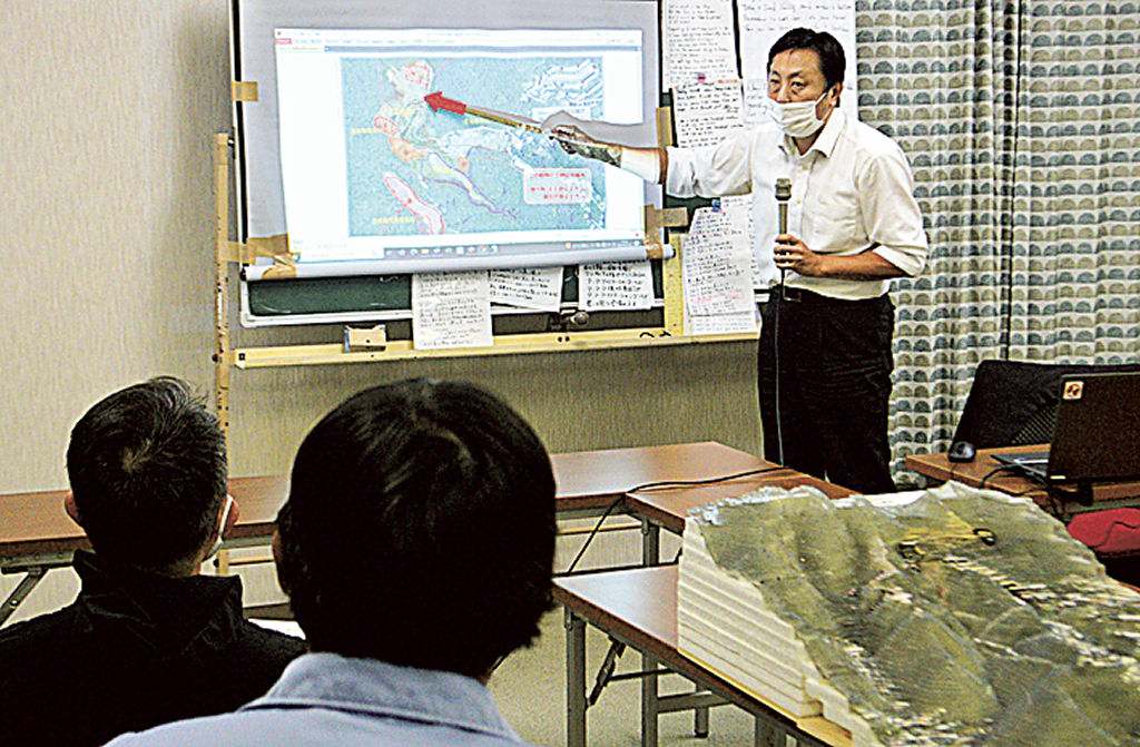 土石流の起点周辺に残る問題を解説する清水浩さん＝１１日午後、熱海市伊豆山