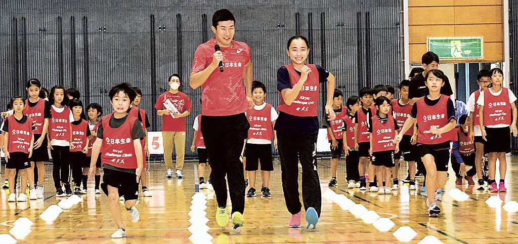 子どもたちに走り方のこつを伝える桐生選手（中央左）＝焼津市保福島の市総合体育館