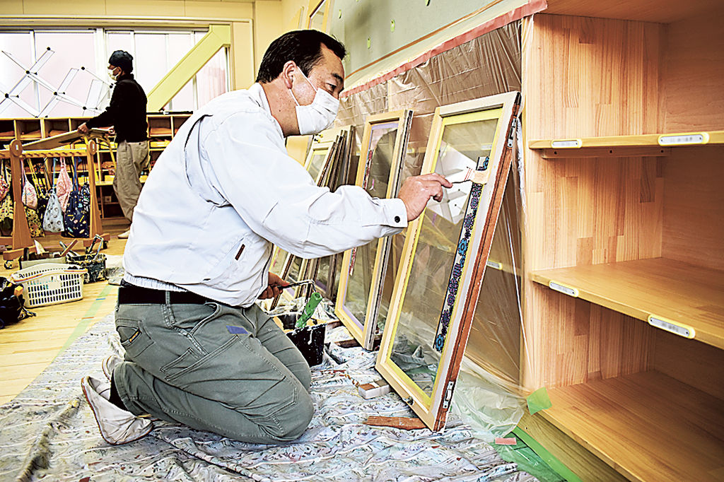 窓枠を塗装する組合員＝浜松市中区常盤町の日本文教幼稚園