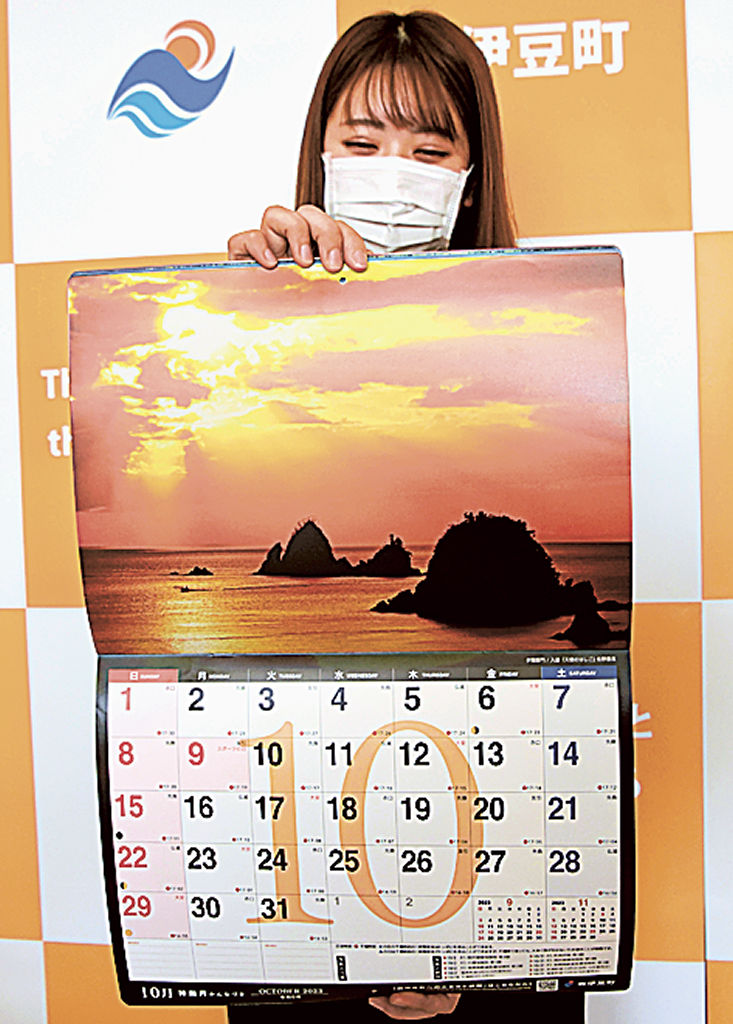 ２０２３年版のカレンダーを見せる職員＝西伊豆町役場