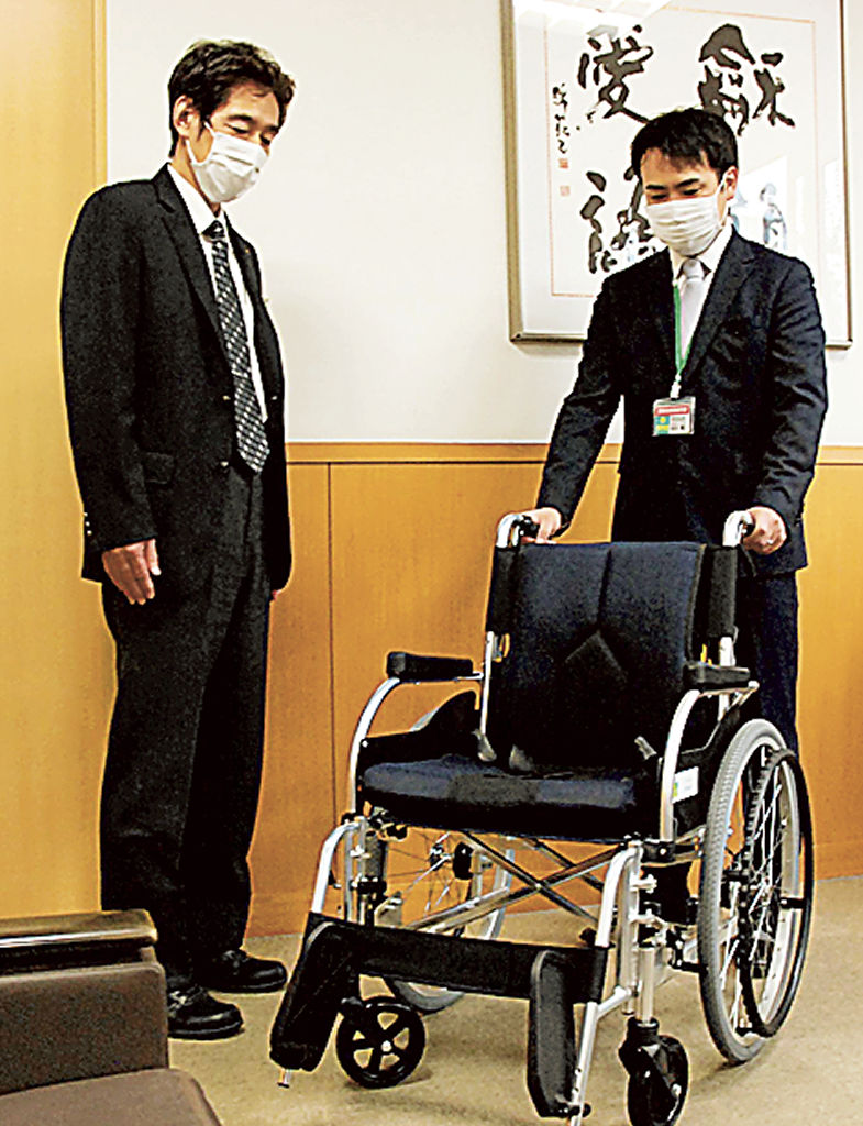 車いすを届けた杏林堂薬局の長谷川さん（右）＝富士市社会福祉協議会