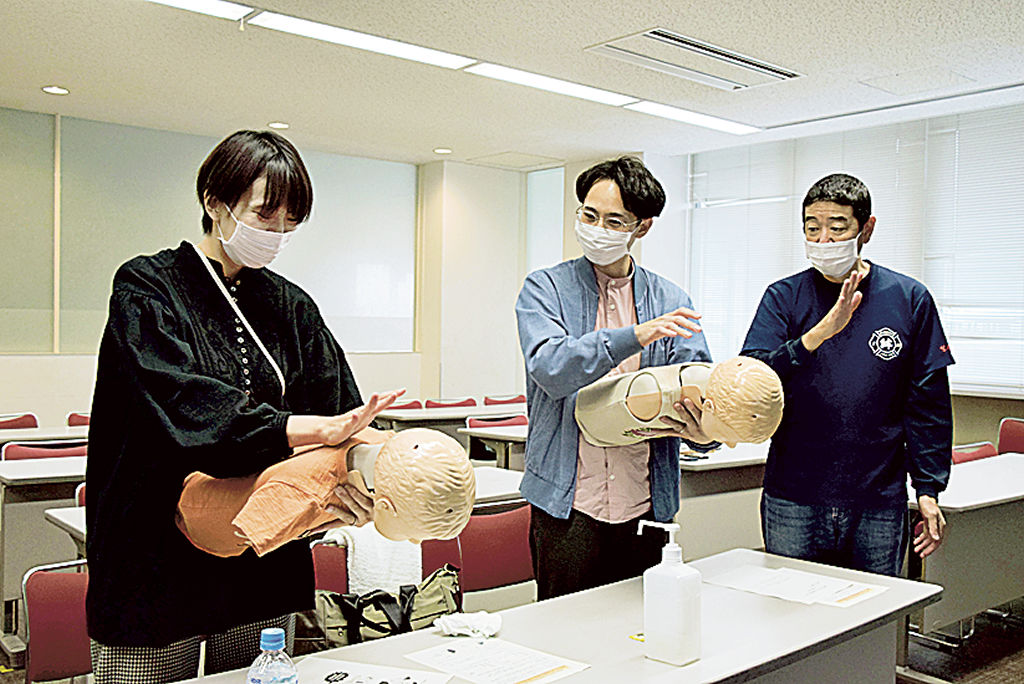 鈴木さん（右）の指導で窒息時の対処法を実践する参加者＝浜松市西区の舞阪協働センター