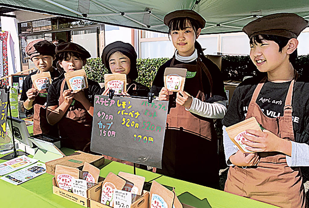 包装デザインを新しくした「本気のハーブティー」を販売する子どもたち＝菊川市