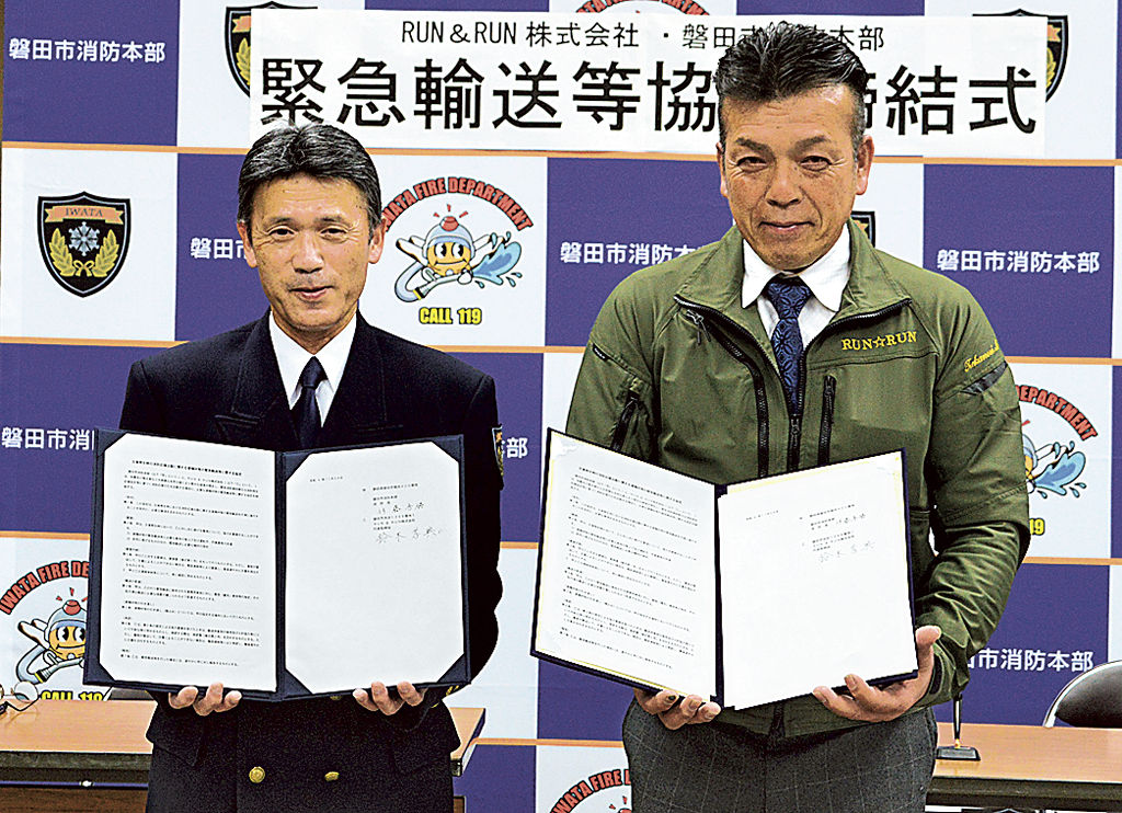 協定書に署名した伊藤消防長と鈴木代表取締役（右）＝磐田市今之浦の市消防署