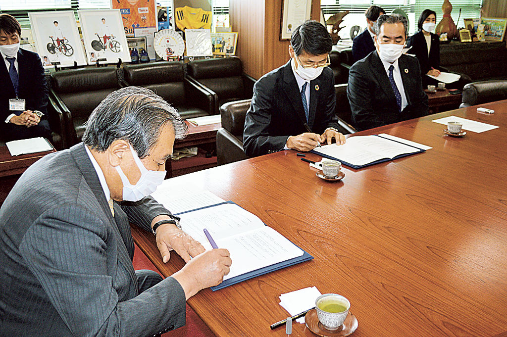 協定書に調印する豊岡市長（左）と岸田社長＝三島市役所