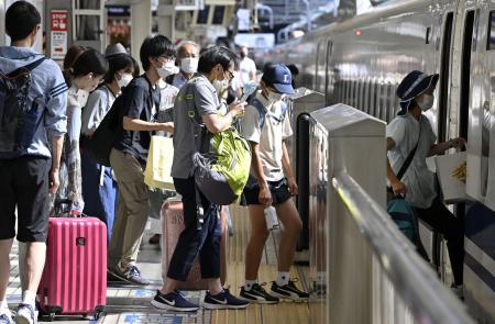 お盆休みの帰省や旅行で混雑したＪＲ東京駅で、新幹線に乗り込む人たち＝８月