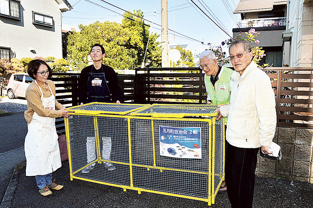 製作した折りたたみ式かごを組み立てる沼田さん親子（左）と自治会員＝１１月中旬、沼津市五月町