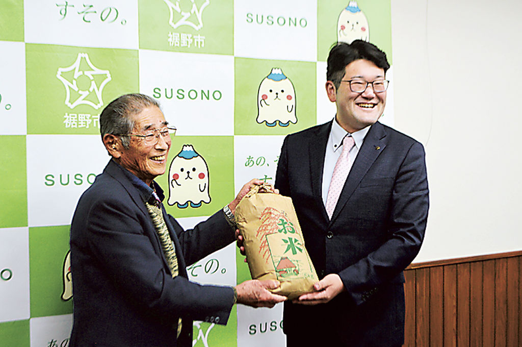 サンプル米を手渡す生産者代表の志村さん（左）＝裾野市役所