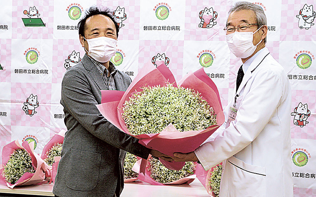 鈴木院長に花束を手渡す服部代表取締役（左）＝磐田市大久保の市立総合病院