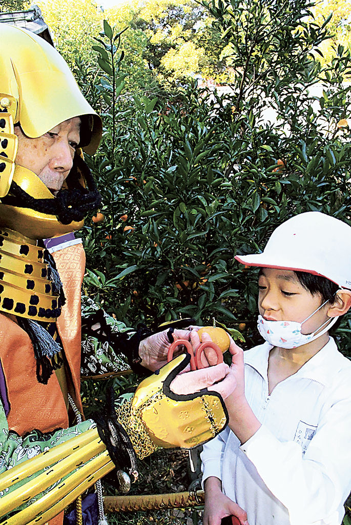 家康の甲冑を着た柳瀬さん（左）とミカンを収穫した児童＝浜松市天竜区二俣町の清瀧寺
