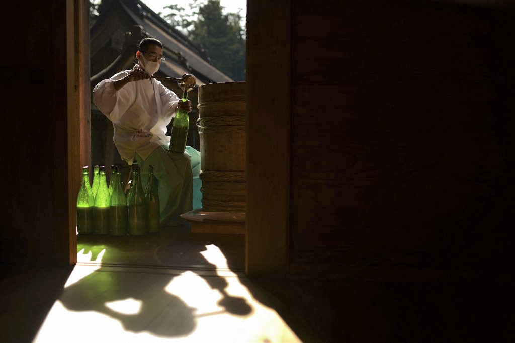 神饌殿で醸造した古式神酒を瓶詰めする神職＝１１月１７日、森町の小国神社