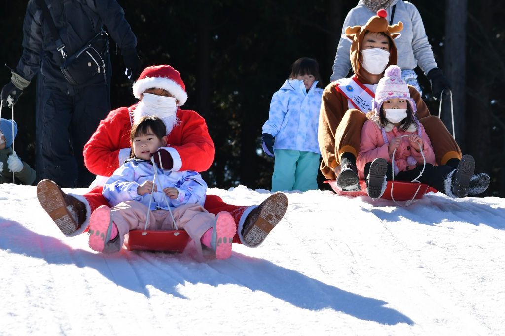 サンタクロースと一緒にそりで滑る園児＝富士市の富士山こどもの国