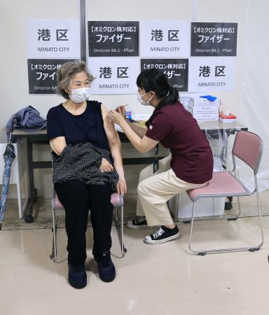 新型コロナウイルスのオミクロン株に対応するワクチン接種を受ける女性（左）＝９月、東京都港区